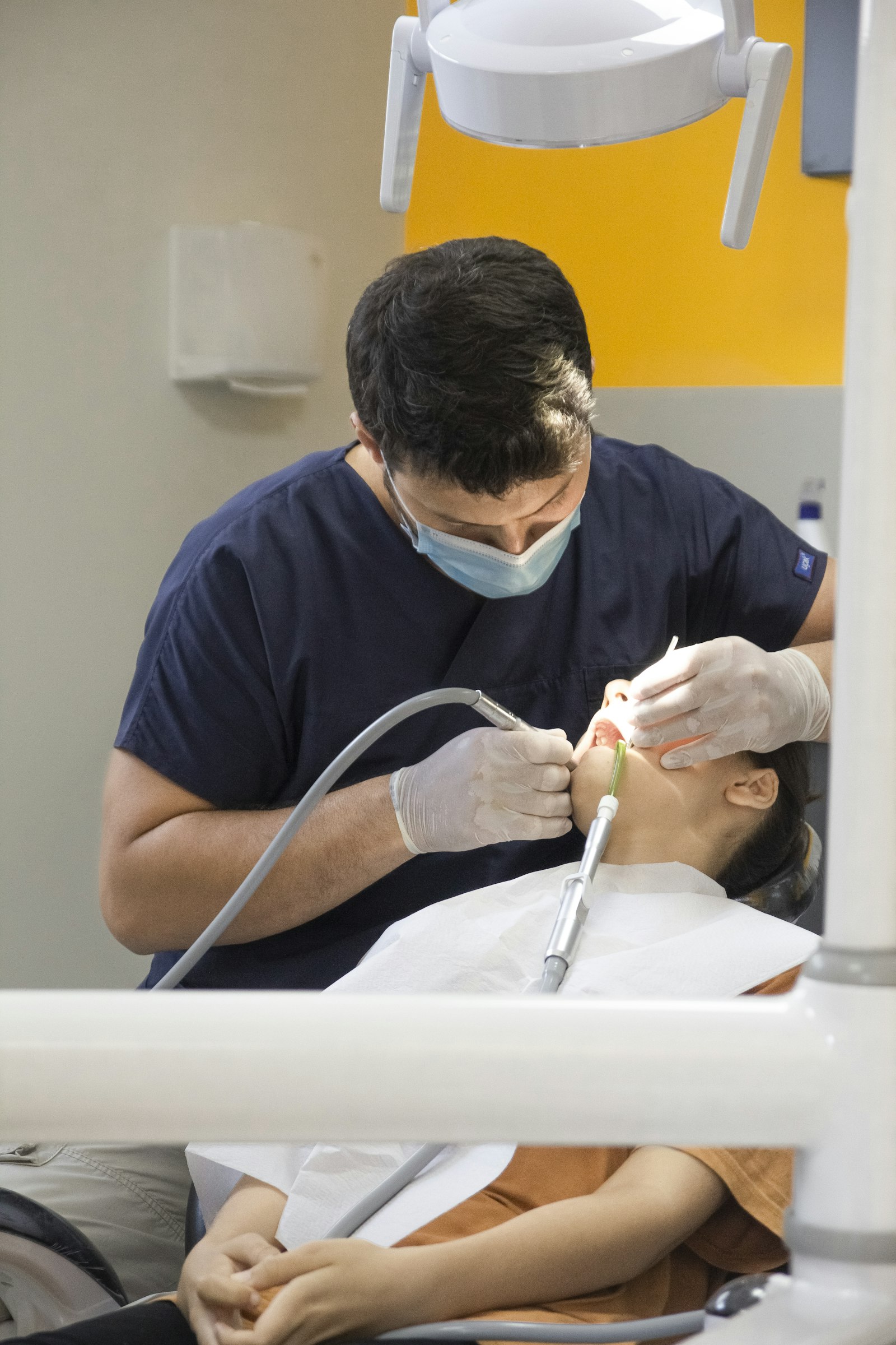 Dentist performing urgent treatment for a patient in the chair